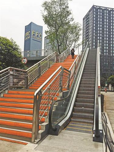 4月11日,财富中心人行天桥的自动扶梯未启用,一位市民正在爬楼梯过